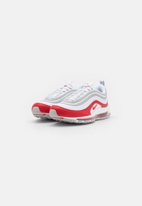 Sneaker Nike Air Max 97 rossi e bianchi con una tomaia liscia, collare imbottito, unità d'aria trasparente e suola in gomma testurizzata.