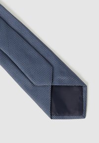 Cravat textil de culoare bleumarin, cu un model țesut; capătul îngust are o căptușeală solidă de culoare închisă.