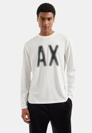 T-shirt bianca a maniche lunghe realizzata in morbido tessuto, con una grande grafica nera "AX" sulla parte anteriore. Stile slim fit, design semplice.