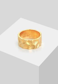 Guld ring med en tekstureret, hamret overflade, der har en let bølget kant. Indeni mærket med "KUZZOI." Glat, blank finish.