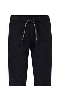 Schwarze Jogginghosen aus weichem Baumwollstoff. Mit einem elastischen Bund und einem Kordelzug, einer Tasche und Markenlogo in Gold am Kordelzug.