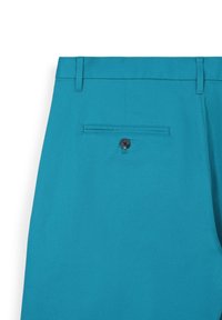 Pantaloni corti turchesi con una texture liscia, dotati di passanti per la cintura, una singola tasca posteriore con chiusura a bottone nero e un design pulito.