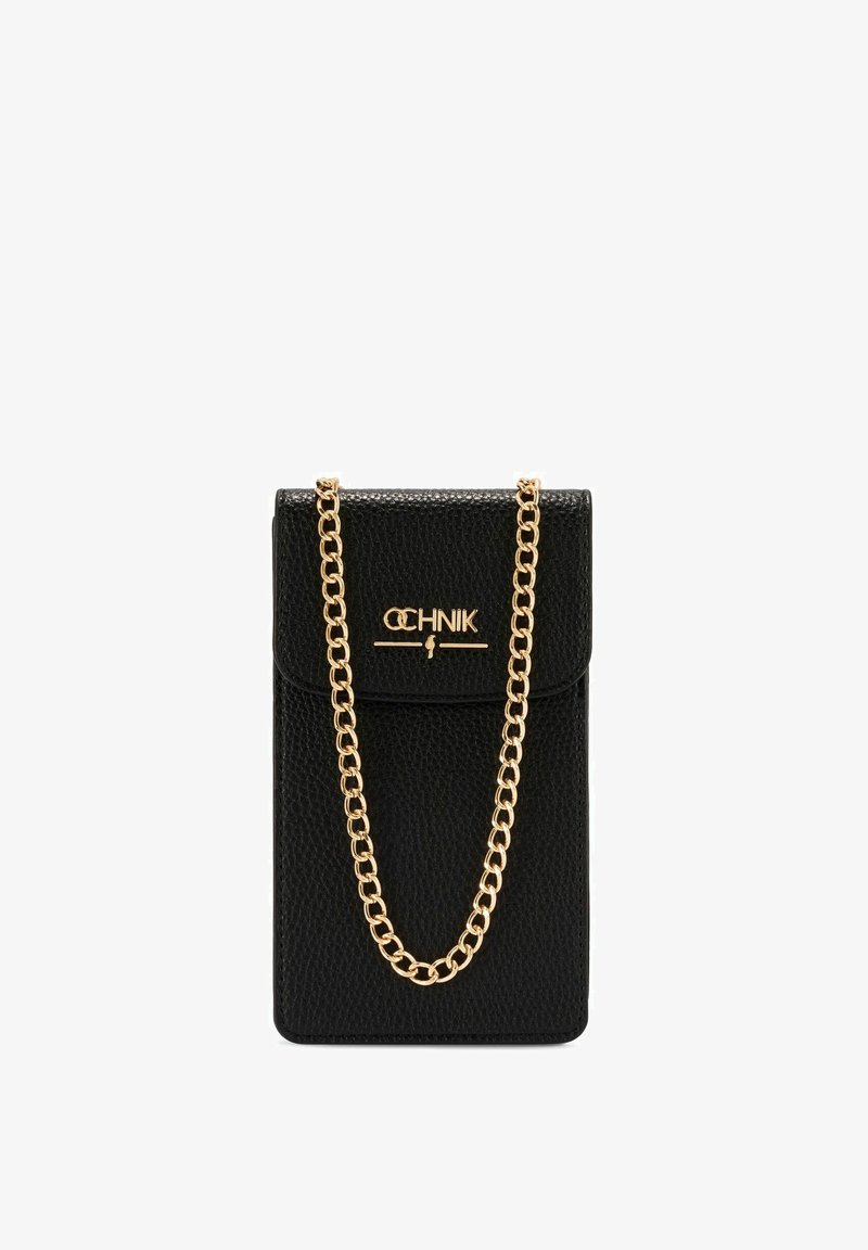Czarna skórzana torba na telefon o teksturowym wykończeniu, z złotym paskiem na łańcuszku i zapięciem na klapkę. Nazwa marki wyeksponowana na złoto.