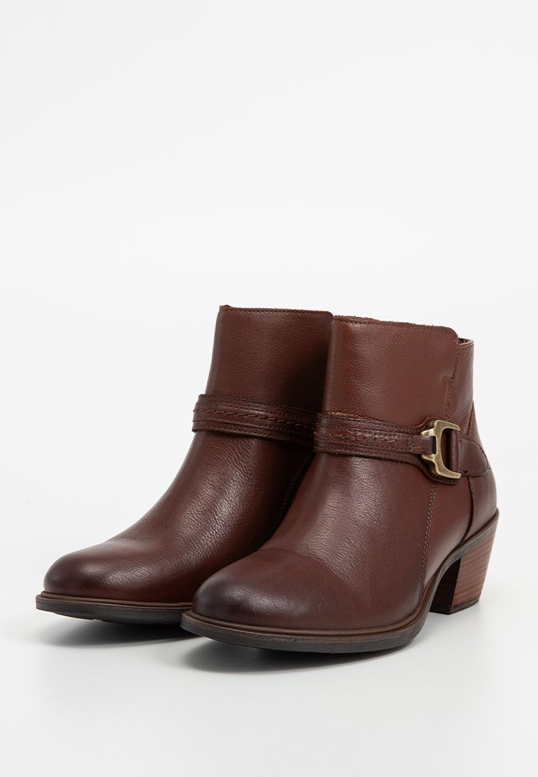 Braune Leder-Ankle-Boots mit einem dekorativen Riemen und Schnallen-Detail, runder Zehenform und einem mittelgroßen Blockabsatz. Glatte Textur, klassisches Design.