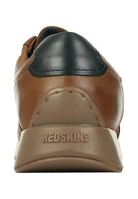 Baskets en cuir marron avec un accent en cuir noir sur le talon, présentant une surface texturée et le logo "REDSKINS" sur la semelle.