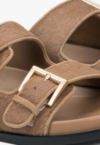 Brown fur-textured sandals with a wide strap, gold buckle hardware, and a smooth beige insole on a black rubber sole.