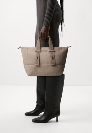 Sac fourre-tout structuré beige avec surface texturée, double anses supérieures et accents de quincaillerie marron contrastants. Bottes noires montantes lisses.