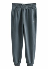 Grijze sportbroek met een elastische tailleband, taps toelopende benen en zijzakken. Heeft een klein "self." logo aan de voorkant. Gladde textuur.