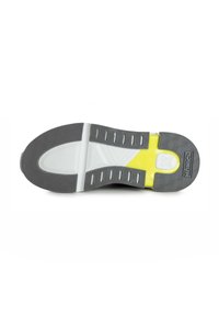 Suola della scarpa con una superficie in gomma grigia a motivo, un'intersuola bianca liscia e un accento giallo brillante. Grip testurizzato per una migliore trazione.