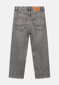 Γκρι τζιν από τζιν ύφασμα με ίσια γραμμή, διαθέτει ολόκληρη πίσω πλευρά με δύο τσέπες, εμφανείς ραφές και δερμάτινο ετικέτα με την επωνυμία στη μέση.