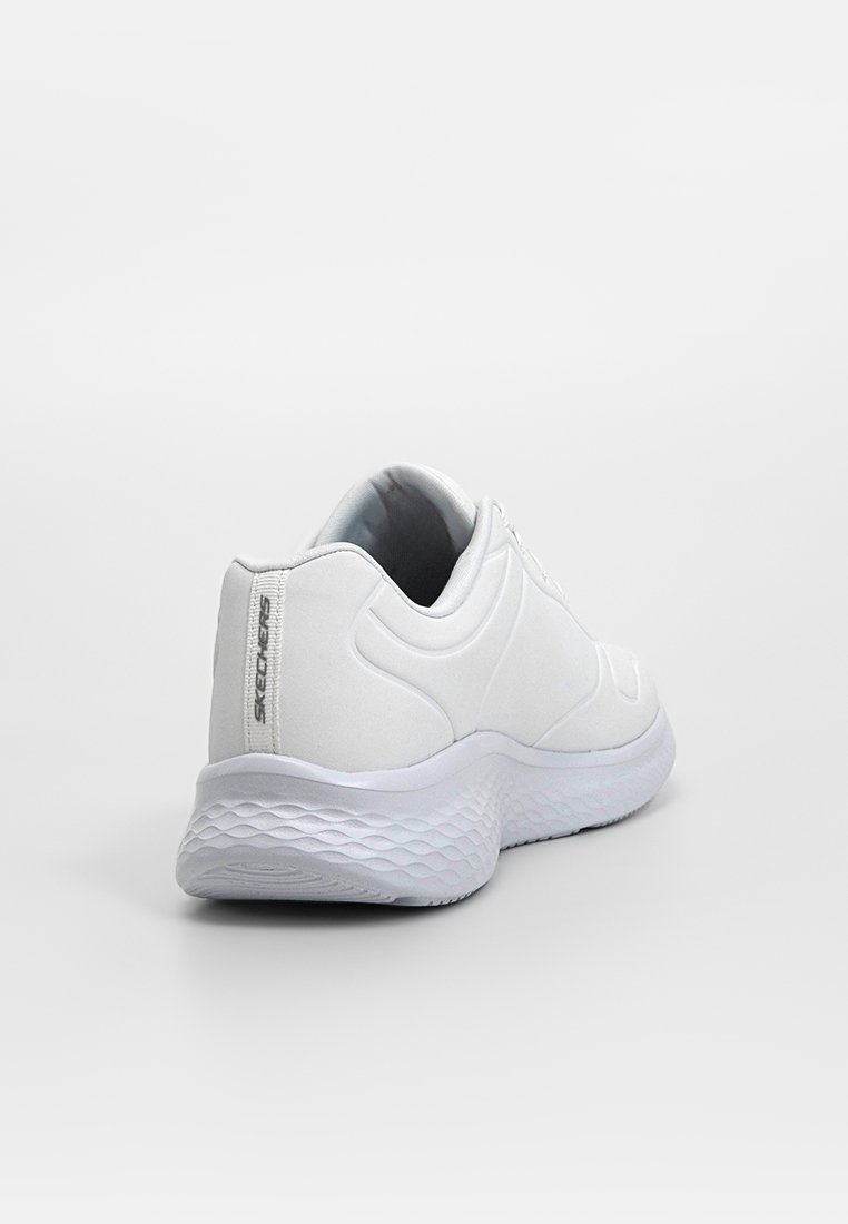 Zapatilla deportiva blanca con parte superior sintética suave, puntera redondeada, suela acolchada y suela texturizada; presenta un detalle de logo en el talón.