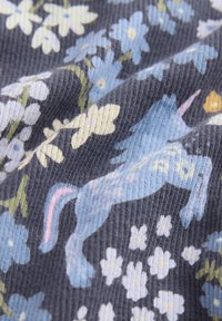 Puuvillakangas, jossa on tummanharmaa tausta ja sinisiä sekä keltaisia kukkakuoseja sekä sininen yksisarvinen pinkillä harjalla.