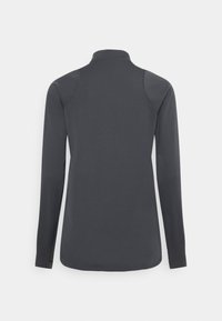 Haut gris foncé à manches longues avec col montant, vu de dos, présentant un tissu simple et lisse et une silhouette près du corps.
