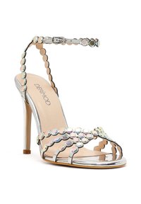 Zilveren sandaal met hoge hak en enkelriem, versierd met iriserende ronde studs en meerdere dunne bandjes over de tenen.