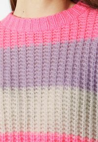 Stickad tröja med horisontella ränder i klarrosa, lavendel, kräm och ljusgrått, med ribbad halsringning och texturerad yta.