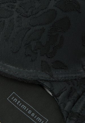 Soutien-gorge en dentelle florale noire avec un tissu texturé, une doublure douce et des détails de motif subtils. L'étiquette indique "intimissimi" à l'intérieur.