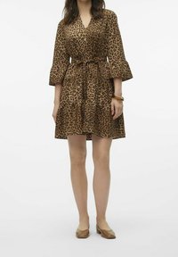 Robe à imprimé léopard avec décolleté en V, manches trois-quarts évasées, taille à nouer et jupe à volants. Fabriquée en tissu léger et texturé.