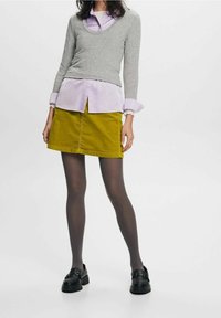 Harmaa ribbattu pitkähihainen neule lilac-kolorisen paidan päällä, yhdistettynä sinappinväriseen corduroy-minihameeseen ja mustiin loafereihin.