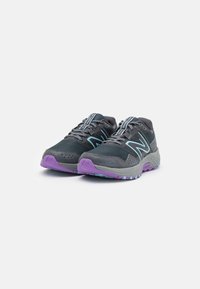 Zapatillas de running grises con una parte superior de malla, acentos azules y una suela morada; cuentan con una entresuela acolchada y una suela texturizada para tracción.