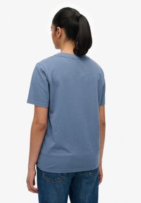 Light blue cotton t-shirt with short sleeves and a crew neck, featuring a straight back hem and no visible patterns or accents.