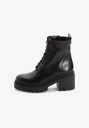 Juodas odinis kulkšninis botas su apvaliu padu, raištelių užsegimu priekyje ir masyviu platformos kulnu. Yra tekstūruotas padas ir kilpa gale.