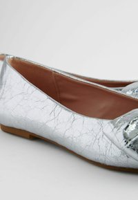 Hopeasävyiset ballerinat, joissa on halkeillut tekstuuripinta, pehmeä nahkavarsi ja pieni, tasapohjainen pohja, jossa on pyöristetty nenädesign.