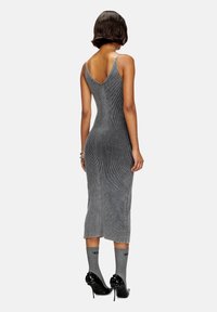 Gray ribbed knit dress with spaghetti straps, mid-calf length, and fitted silhouette. Worn with gray socks and black high-heel shoes.