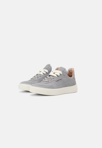 Sneaker grigi in pelle e tessuto, con profilo basso, punta rotonda, suola in gomma bianca e lacci crema. Dettagli testurizzati lungo i lati.
