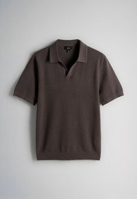 Polo en maille marron foncé à manches courtes avec col et ouverture en V sur un fond gris clair uni.