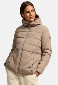 Beige gewatteerde jas met capuchon, voorzien van een ritssluiting aan de voorkant, zijzakken met drukknoop en een doorgestikt ontwerp. Zachte, gladde textuur.