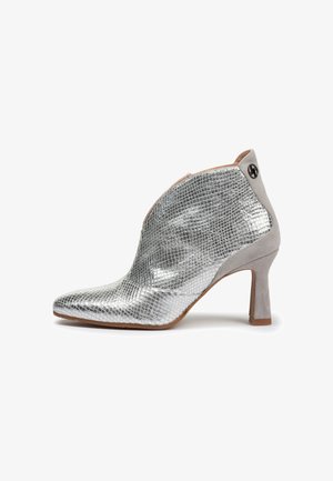 Botines plateados con un patrón de piel de serpiente texturizado, puntera puntiaguda, un acento de ante gris y un tacón moderado que añade elegancia.