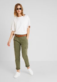 Noisy May - Kangashousut - olive night - 1