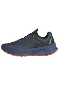 Scarpa da corsa GORE-TEX in navy, nero e rosso. Caratterizzata da una tomaia in mesh testurizzato, colletto imbottito e suola in gomma resistente con modelli di trazione.