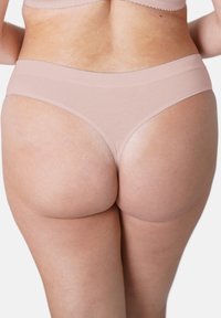 Helle rosa Baumwoll-Tanga mit nahtlosem Taillenbund und glatter Textur, der ein hochgeschnittenes Bein-Design für minimale Bedeckung aufweist.