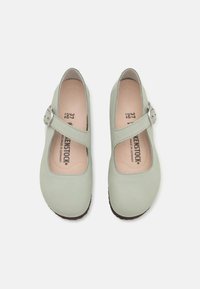 Zapatos Mary Jane de color verde menta con puntera redonda, parte superior de cuero, correa ajustable con hebilla plateada y plantilla acolchada. Suela de goma.