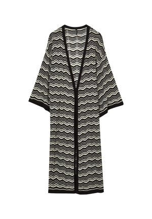 Long cardigan ouvert avec un motif en chevrons noir et blanc et des manches larges, bord noir le long des bords et des poignets.