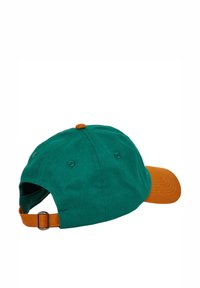 Gorra ajustable de diseño bicolor; tela verde oscuro con visera y correa en color marrón anaranjado. Cuenta con un botón en la parte superior y agujeros de ventilación.
