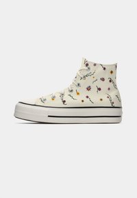 Sapatilha de lona de cano alto em creme com bordado floral multicolorido, bico em borracha branca e sola espessa branca com riscas pretas.