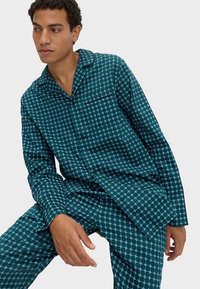 Teal patterned pajama set featuring a geometric design, button-up shirt with pocket, and matching pants with a relaxed fit.