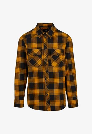 Camisa de franela con un patrón de cuadros amarillo y negro, mangas largas, dos bolsillos en el pecho, cierre de botones en la parte delantera y un corte relajado.