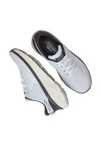 Scarpe da atletica leggere con tomaia in rete bianca, dettagli grigio scuro e suola testurizzata; presentano lacci spessi e imbottitura per il comfort.