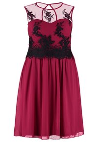 Těhotenské šaty v burgundské barvě s černou krajkovou aplikací na bodice a průhlednými ramínky, splývavá sukně pod pasem. Elegantní a formální design.