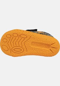 Suela de zapato negra con una suela exterior de goma texturizada naranja. Presenta patrones de agarre elevados y un logo de marca grabado.