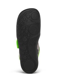 Black rubber shoe sole with circular and bubble patterns; features a green accent on the side and is grey with a textured surface.