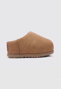 Zoccoli in suede con slip-on color marrone chiaro, punta arrotondata, superficie testurizzata e suola in gomma resistente con motivo di battistrada per una buona presa.