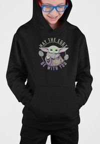 Svart hoodie med grafisk motiv av en grön karaktär med stora öron och texten "MÅ ÄNGERNA VARA MED DIG." Framsidan har en kenguruficka.