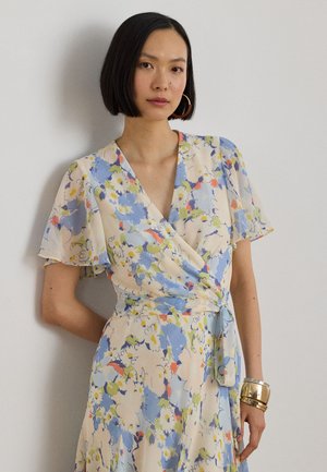 Robe portefeuille fleurie en tissu léger. Elle présente des fleurs bleues, jaunes et orange sur un fond crème, avec des manches courtes évasées et une ceinture à nouer.