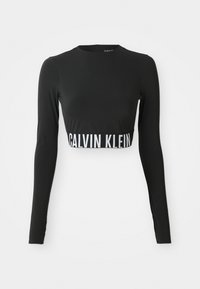 Schwarzes langärmliges Crop-Top mit hohem Kragen und einem weißen "Calvin Klein"-Logoband um die Taille.