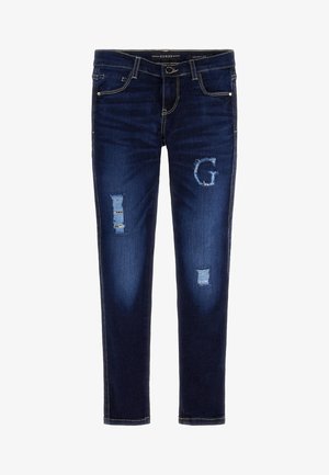 Dark blue skinny jeans with distressed patches, including a "G" shaped tear on the right thigh and classic five-pocket design.