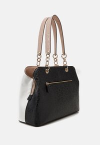 Sort og hvid håndtaske med guldfarvet hardware, der har en tekstureret overflade, en lynlåslomme og dobbelt sløjfede håndtag med en glat finish.